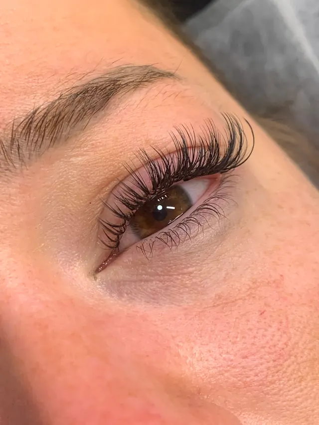 Wispy wet lash extensions with soft spikes and a glossy finish